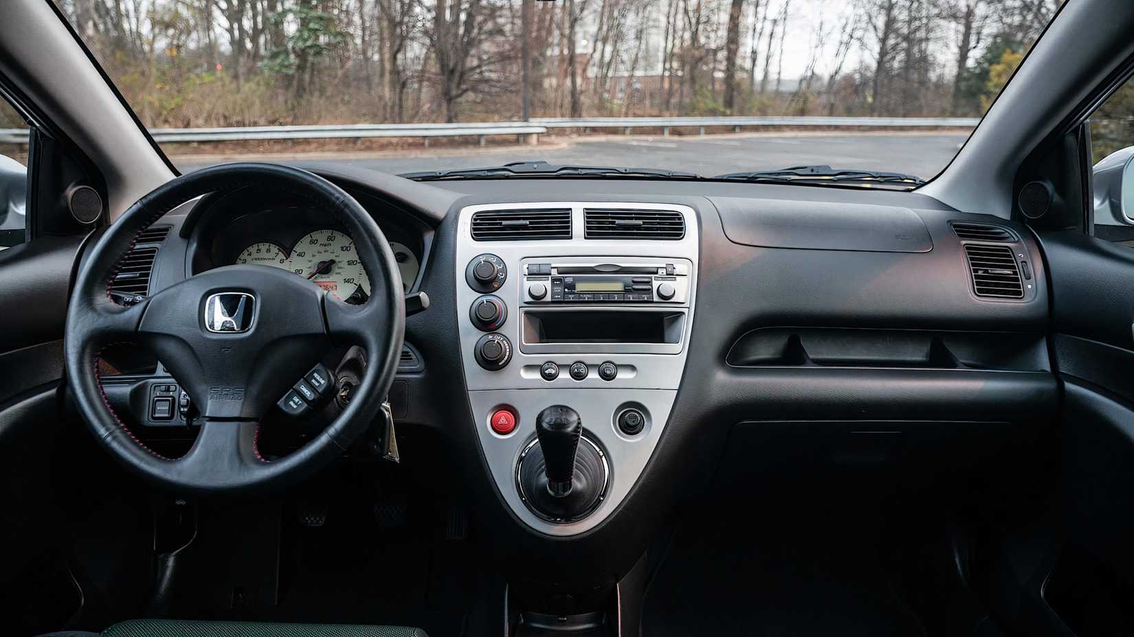 2003 Honda Civic Si interior showing dashboard, gear shift, and steering wheel