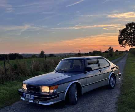 1985 Saab 900 Turbo estacionado em estrada de cascalho ao pôr do sol