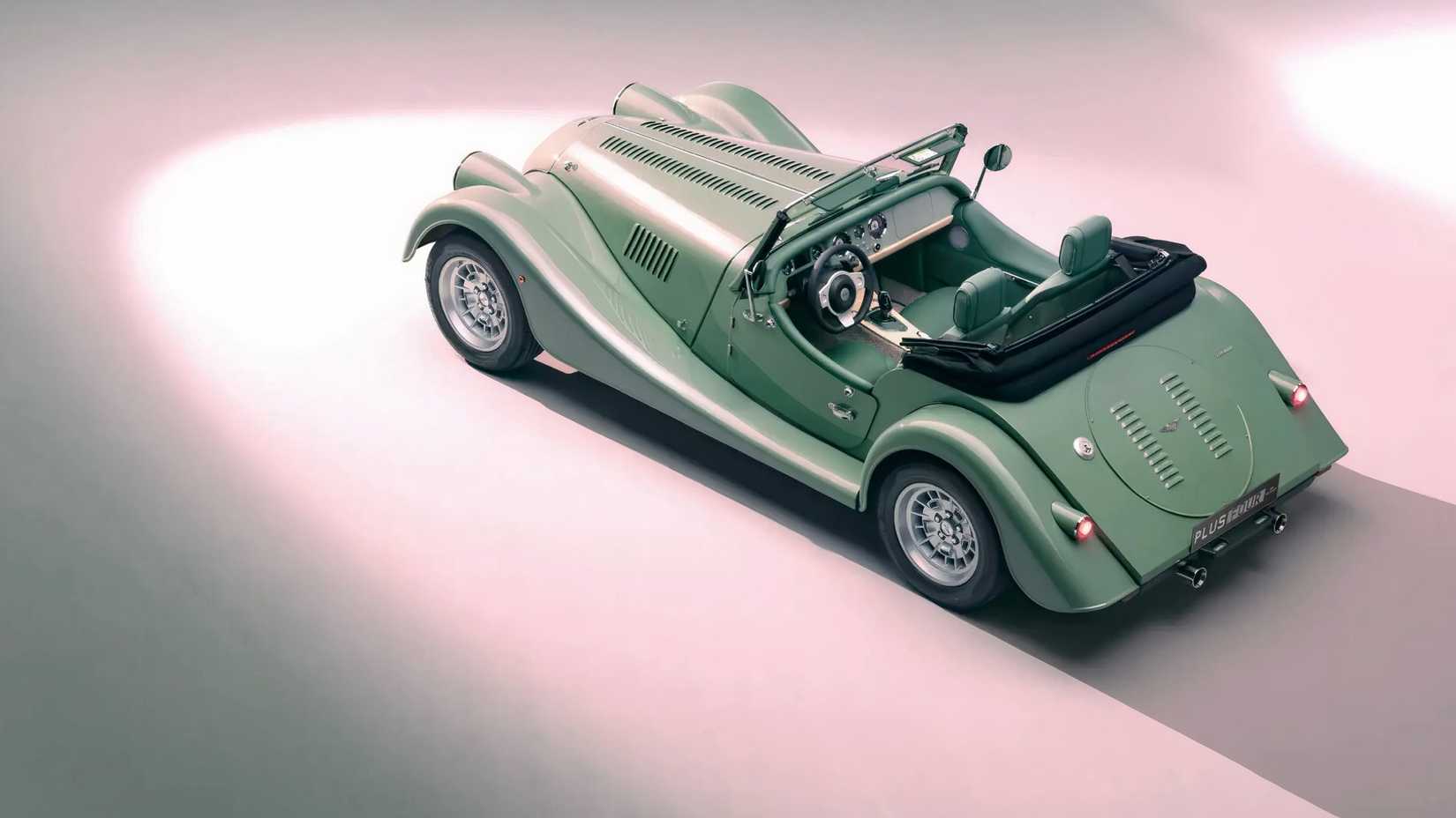 Morgan Plus Four em verde estacionado em estúdio