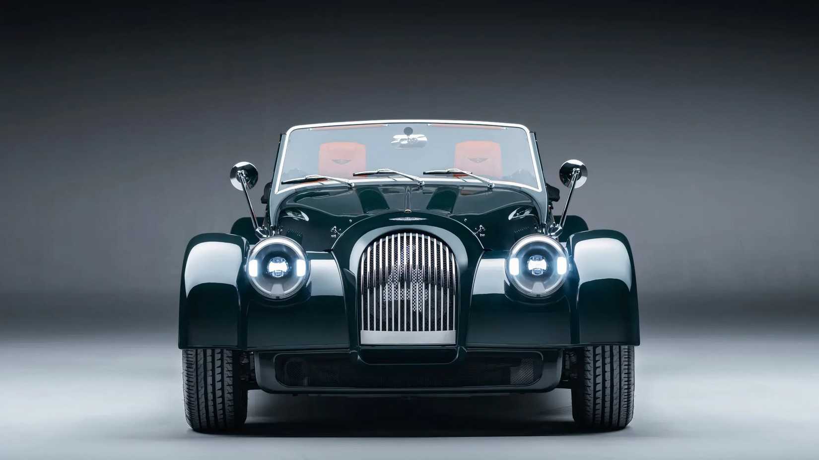 Morgan Plus Four em verde estacionado em estúdio