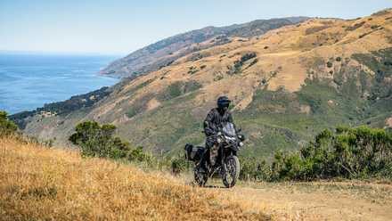 Foto da Kawasaki KLR650 Adventure viajando off-road em frente à rota costeira