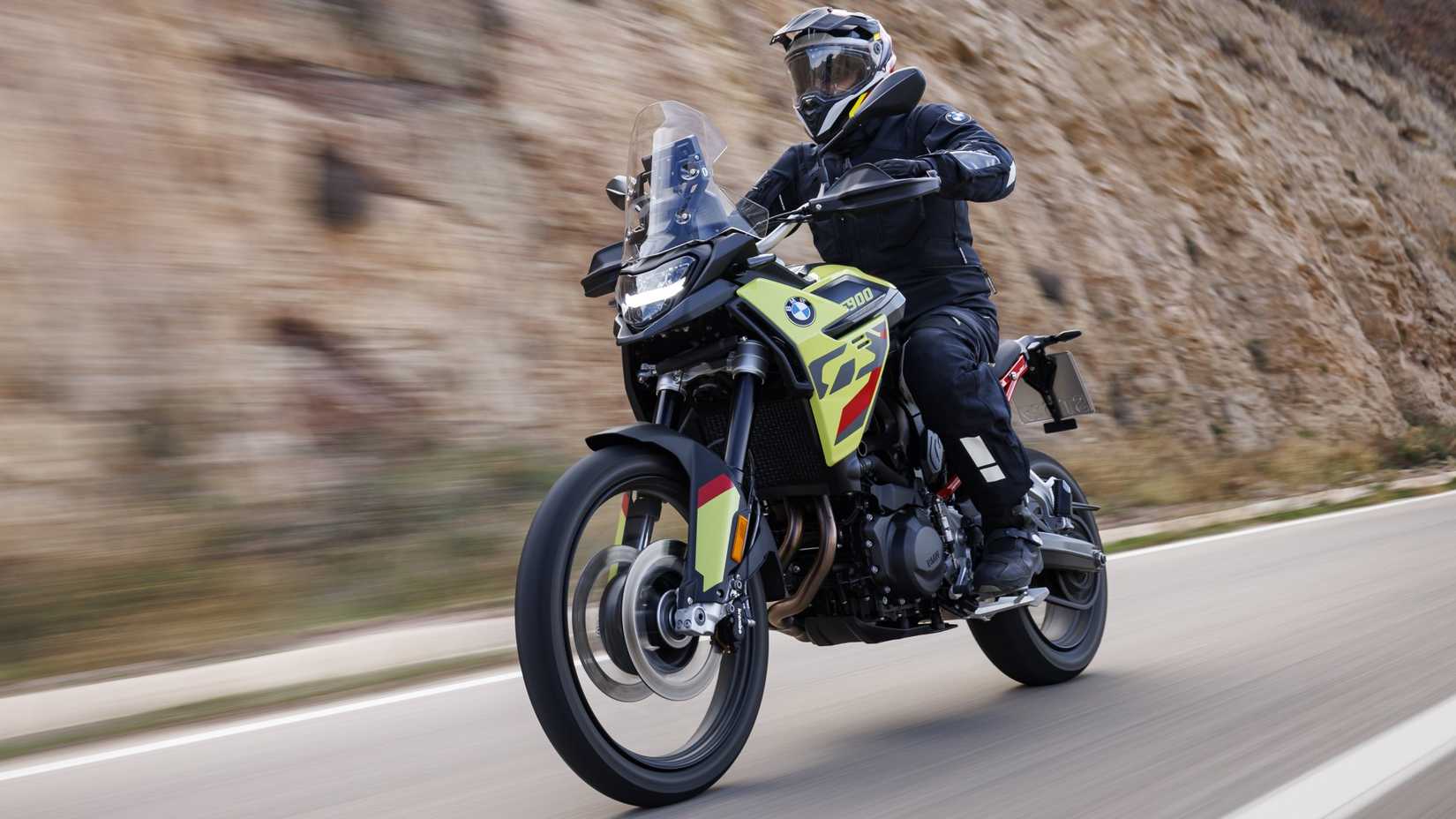 2025 BMW F 900 GS acelerando na frente da estrada, vista do terceiro trimestre