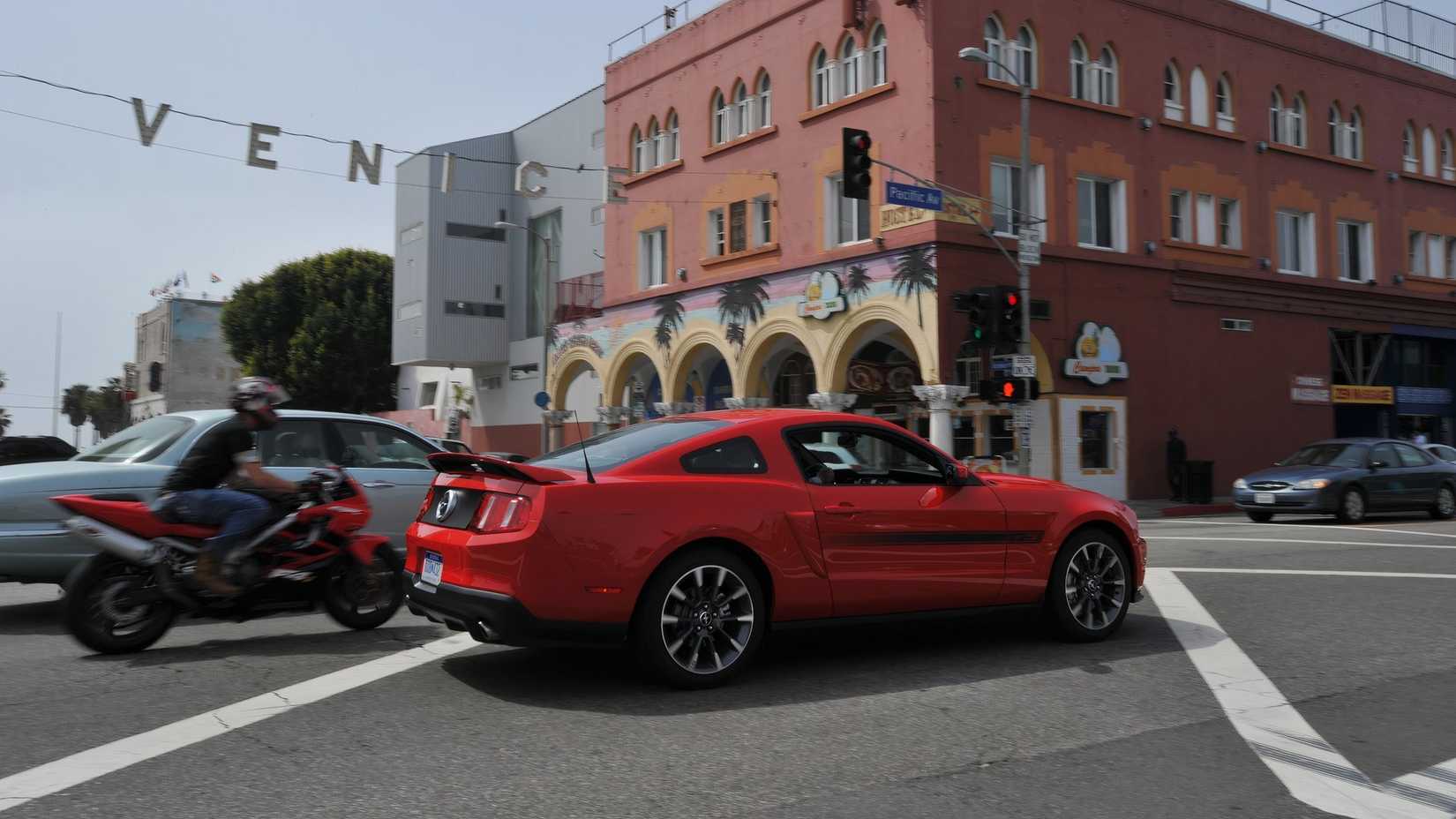 Red 2011 Ford Mustang GT in city traffic