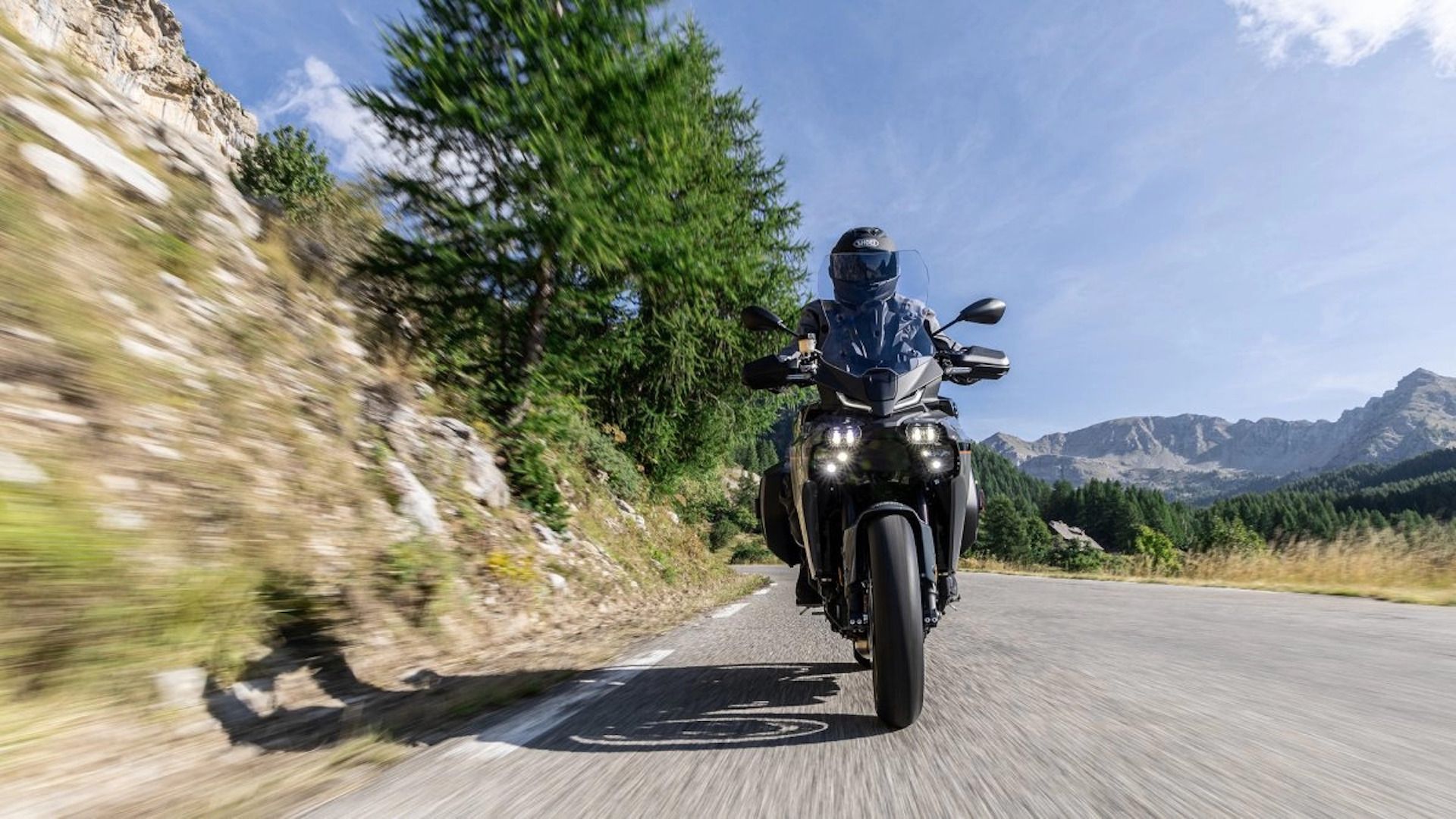 Yamaha Tracer 9 navegando em uma estrada rural com vista para o painel frontal