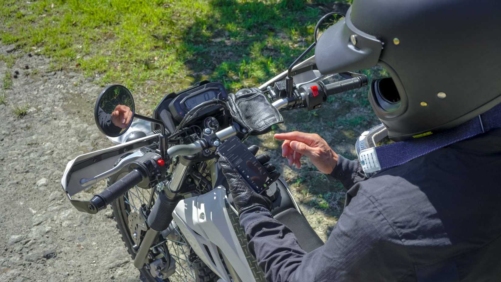 Rider conectando seu telefone ao 2026 Kawasaki KLX230 Sherpa S