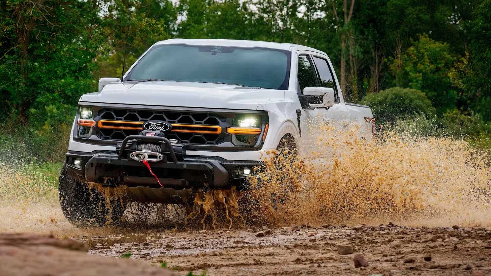 2025 Ford F-150 in white driving through mud and water