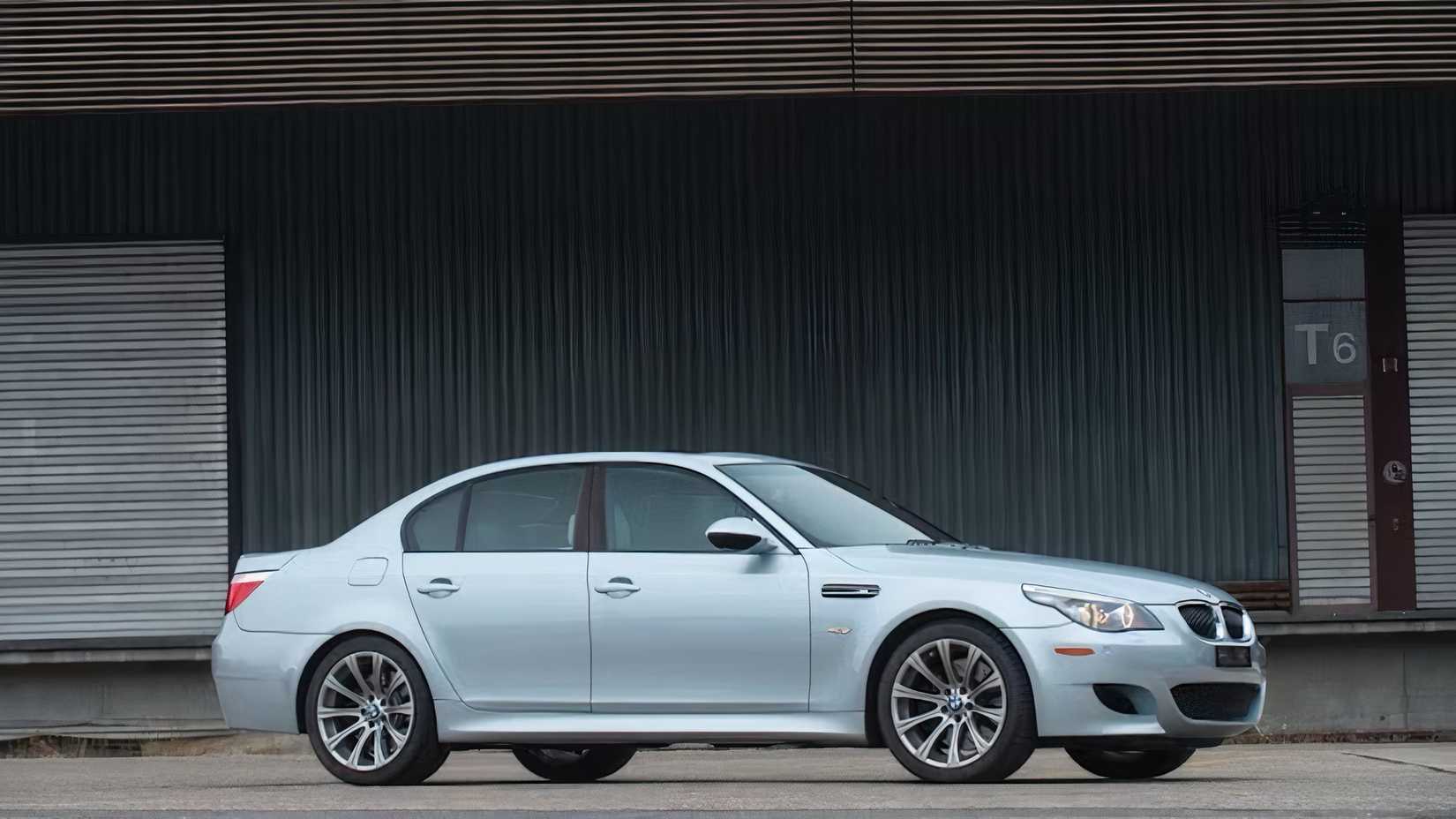 2010 BMW M5 E60 em prata estacionado em frente à garagem