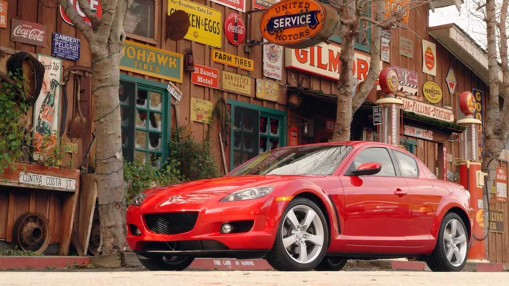 Mazda RX-8 2008 em vermelho estacionado na rua em frente à loja