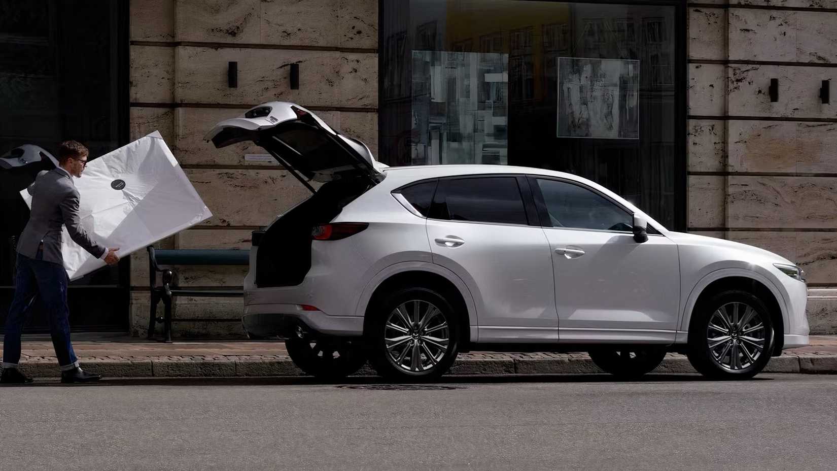 2022 Mazda CX-5 in white parked on city street being loaded