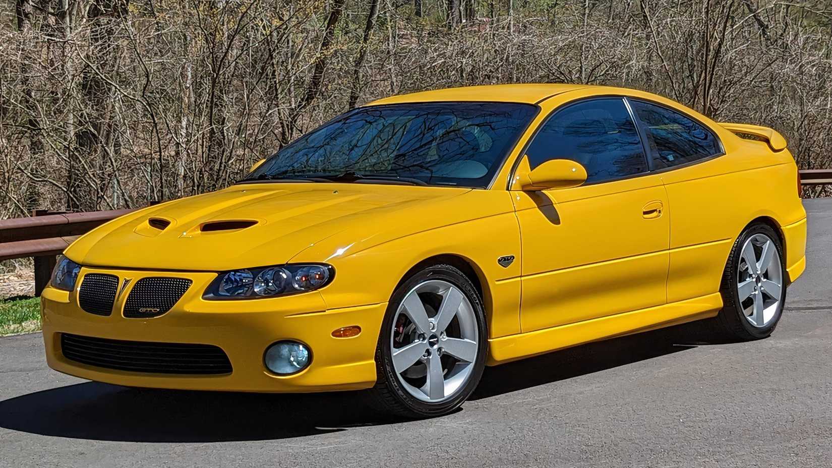 Vista lateral 3/4 do Pontiac GTO 2005 estacionado na estrada