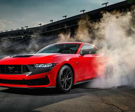 Vista frontal 3/4 do Ford Mustang Dark Horse 2025 fazendo um burnout