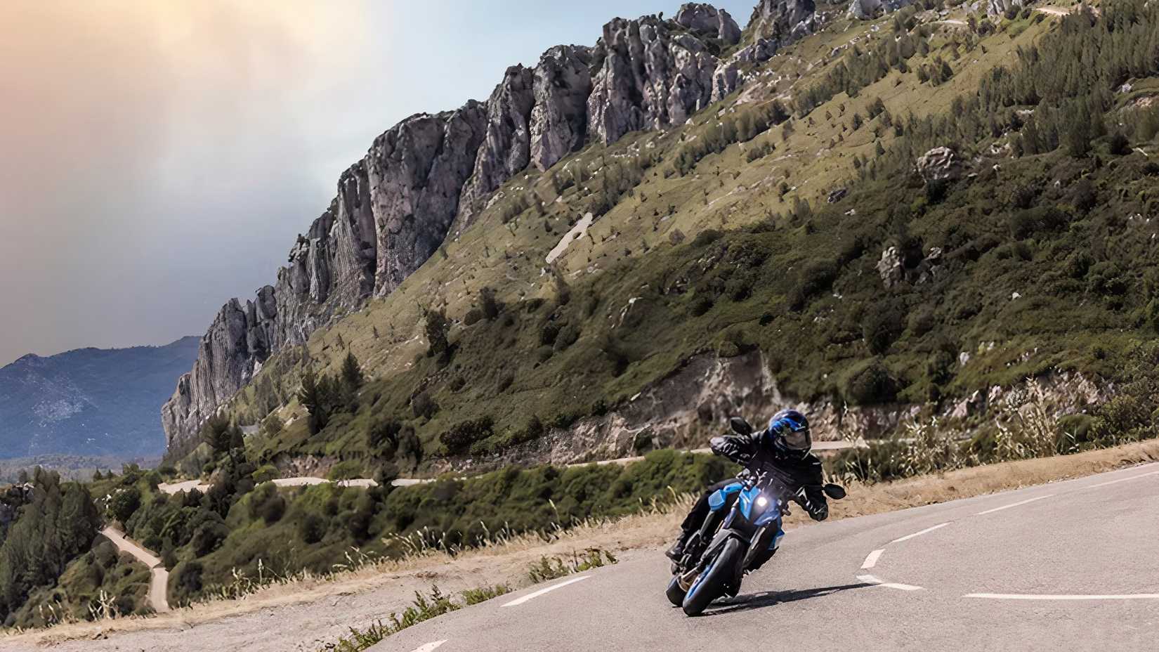 Foto da Suzuki GSX-8S fazendo curvas em uma estrada de montanha