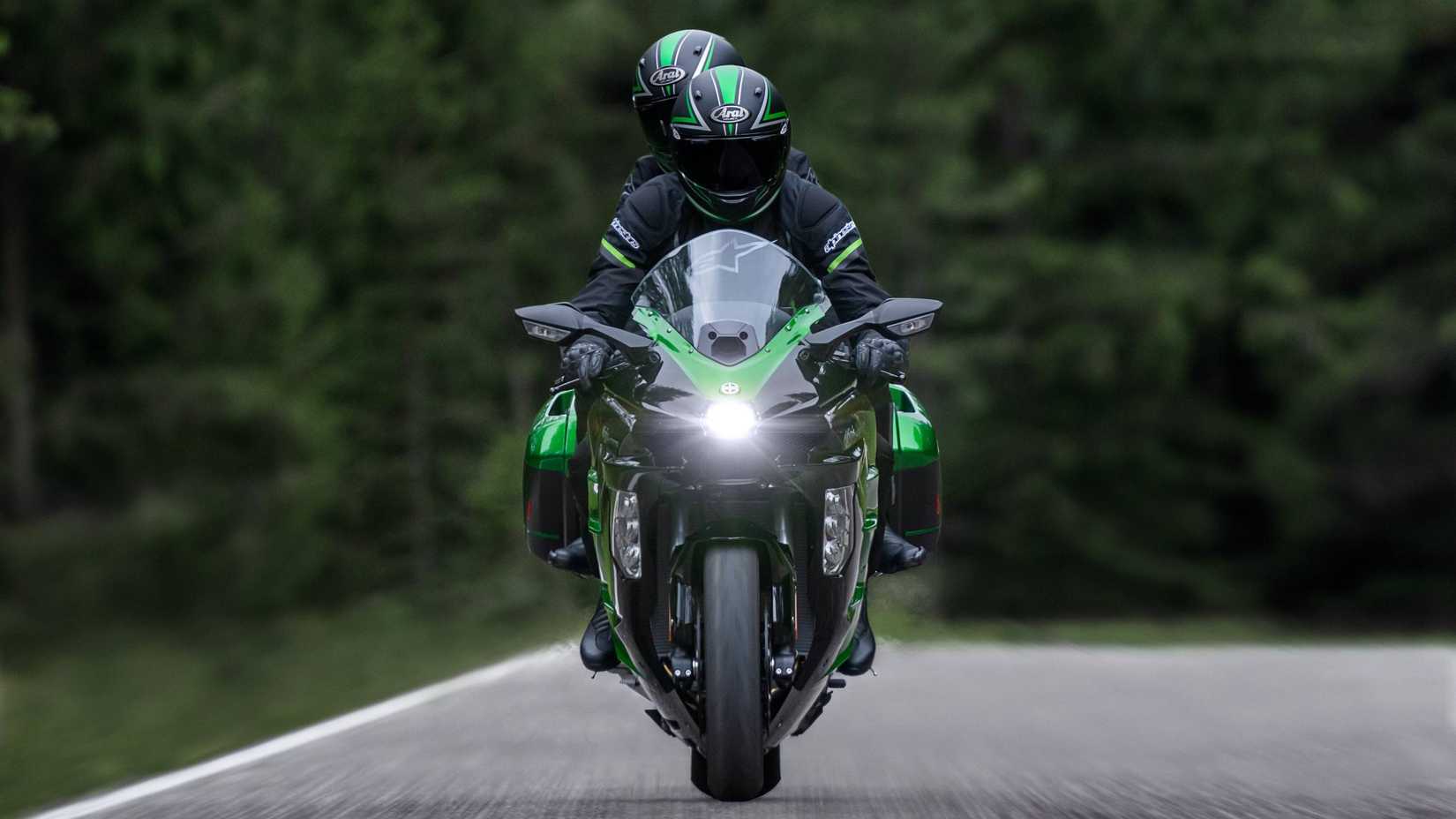Uma foto frontal da Kawasaki Ninja H2 SX SE 2025 com o piloto e o passageiro