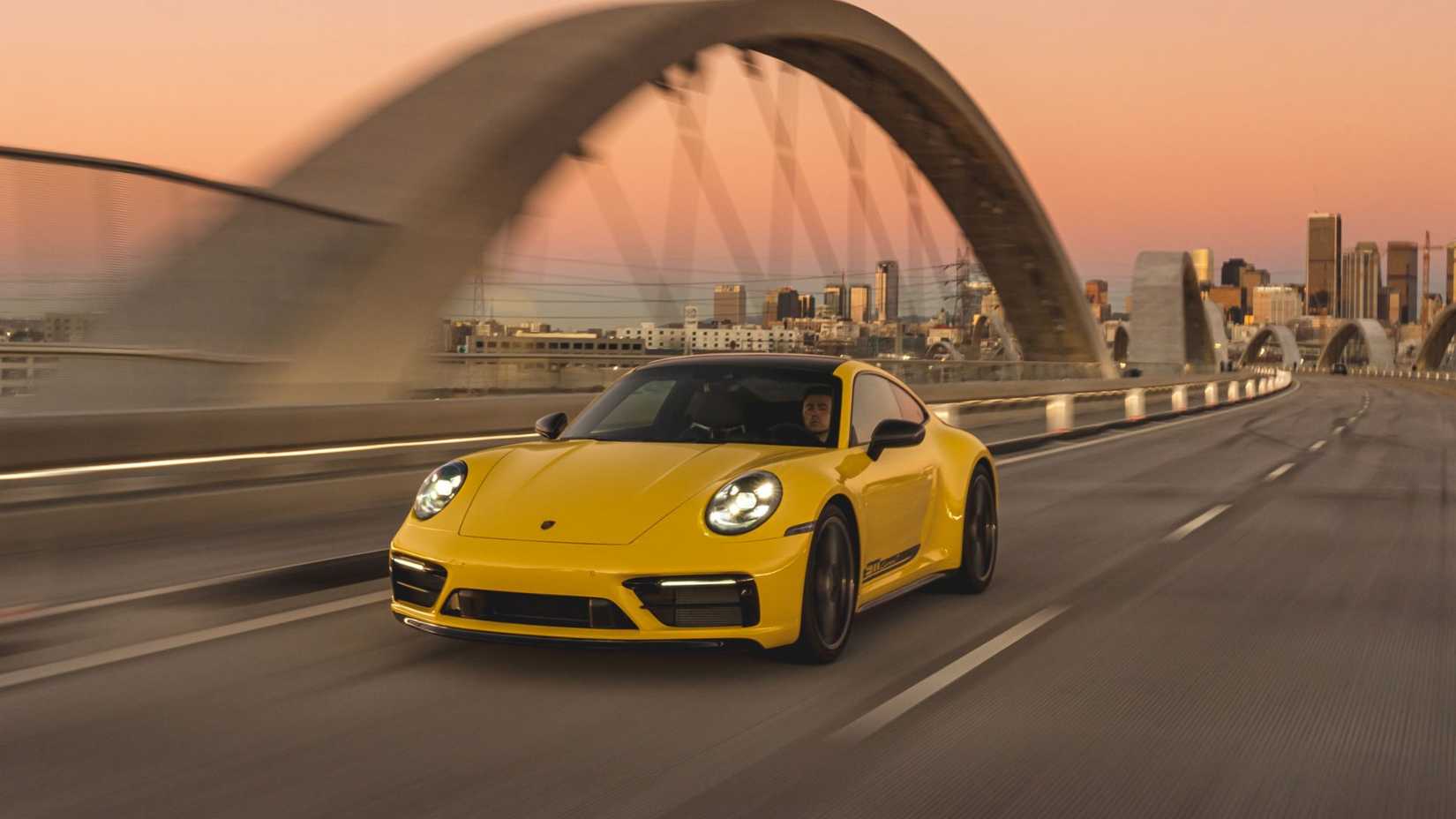 2025 Porsche 911 Carrera T front 3/4 shot driving over bridge