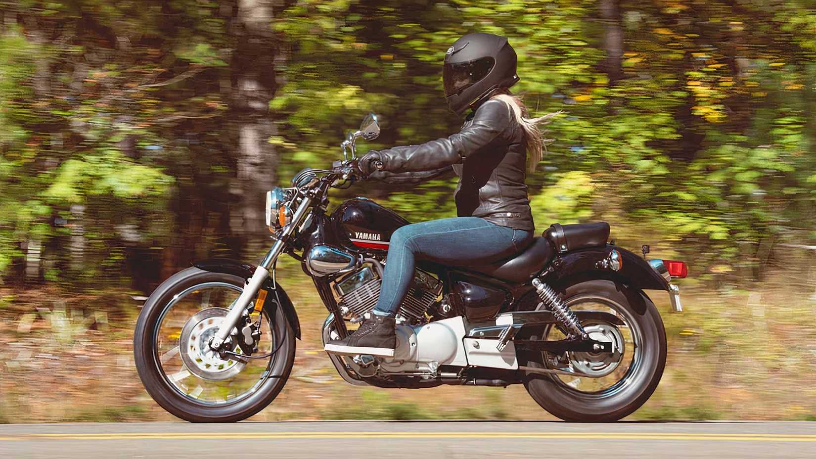 A side view of a woman riding a 2025 Yamaha V-Star 250