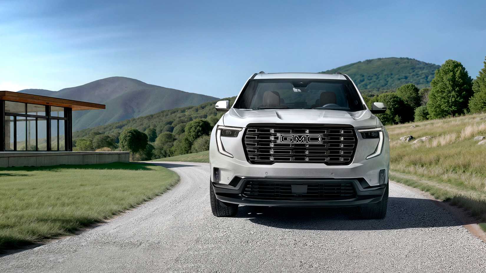 Um 2026 GMC Acadia Denali Ultimate branco estacionado em uma garagem exibindo seu painel frontal.