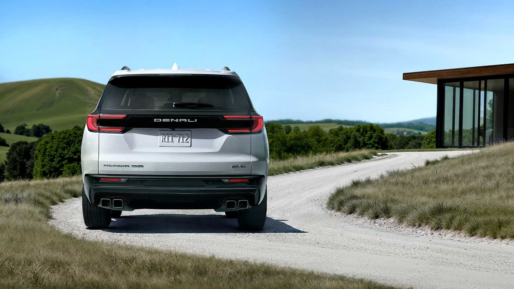 Um 2026 GMC Acadia Denali Ultimate branco estacionado na curva de uma garagem