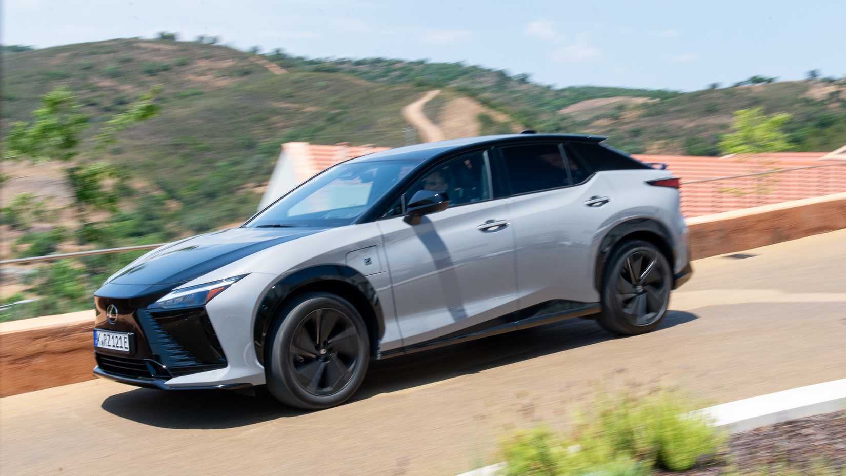 Profile action shot of 2026 Lexus RZ 550e F Sport driving on road