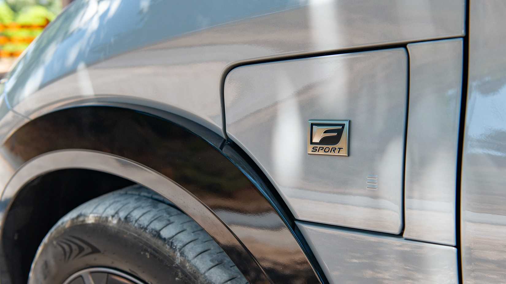 2026 Lexus RZ 550e F Sport AWD close-up do emblema e da porta de carregamento