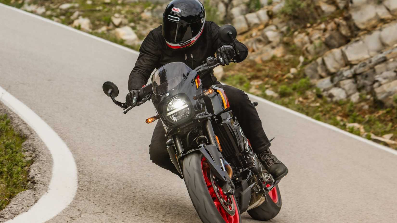 2026 Suzuki GSX-8TT inclinada em uma curva em uma estrada de montanha