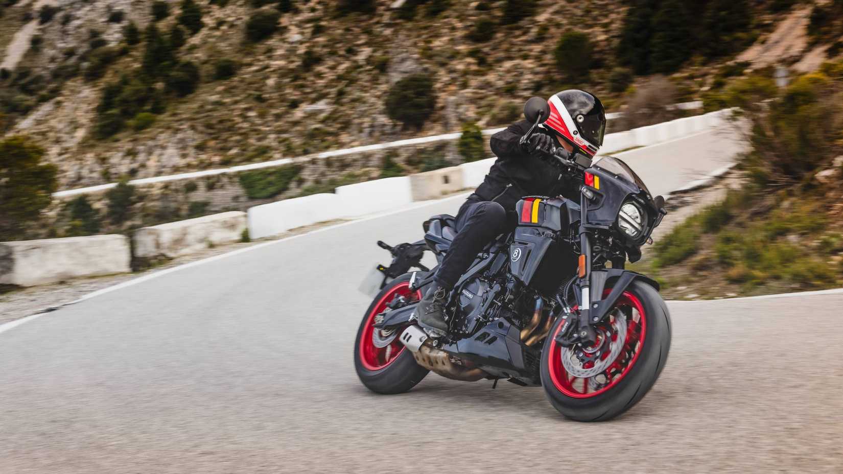 2026 Suzuki GSX-8TT contornando uma curva subindo uma colina em uma estrada de montanha