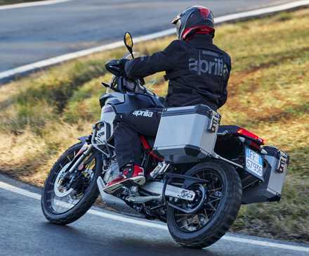 Aprilia Tuareg com cestos na estrada traseira vista do terceiro quarto