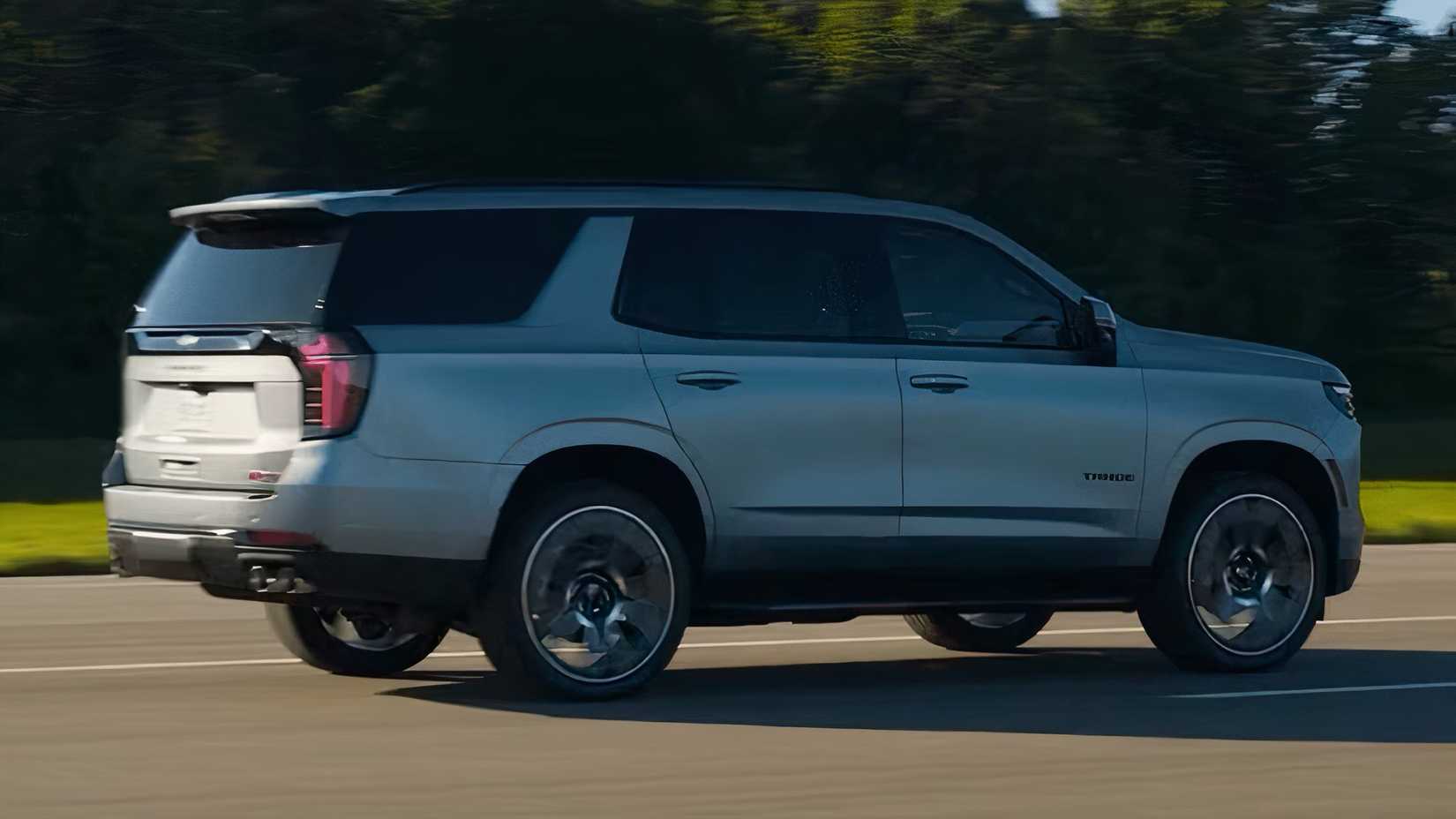 Foto de ação 3/4 traseira do Chevrolet Tahoe 2025 em prata dirigindo na estrada