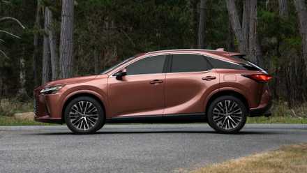 Foto de perfil do Lexus RX 2025 em bronze estacionado na estrada