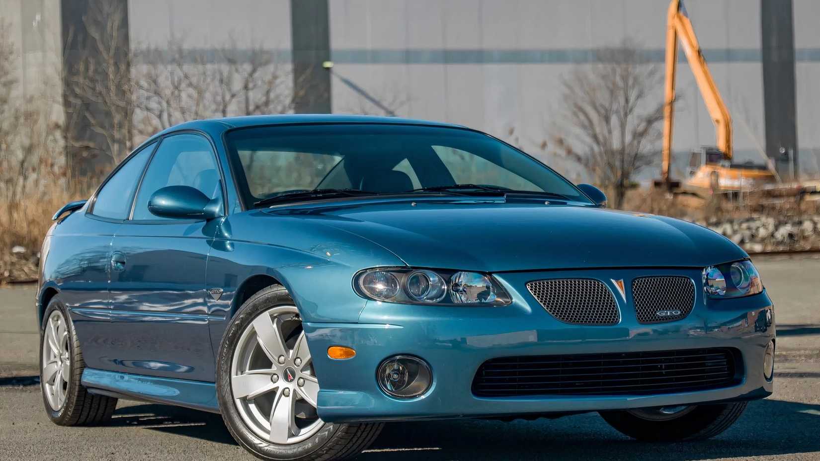 Um Pontiac GTO 2004 estacionado em um terreno aberto