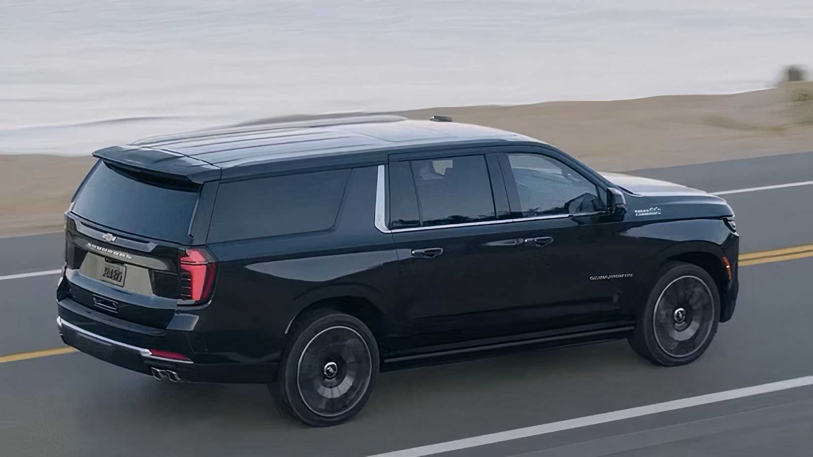2025 Chevrolet Suburban in black driving on road