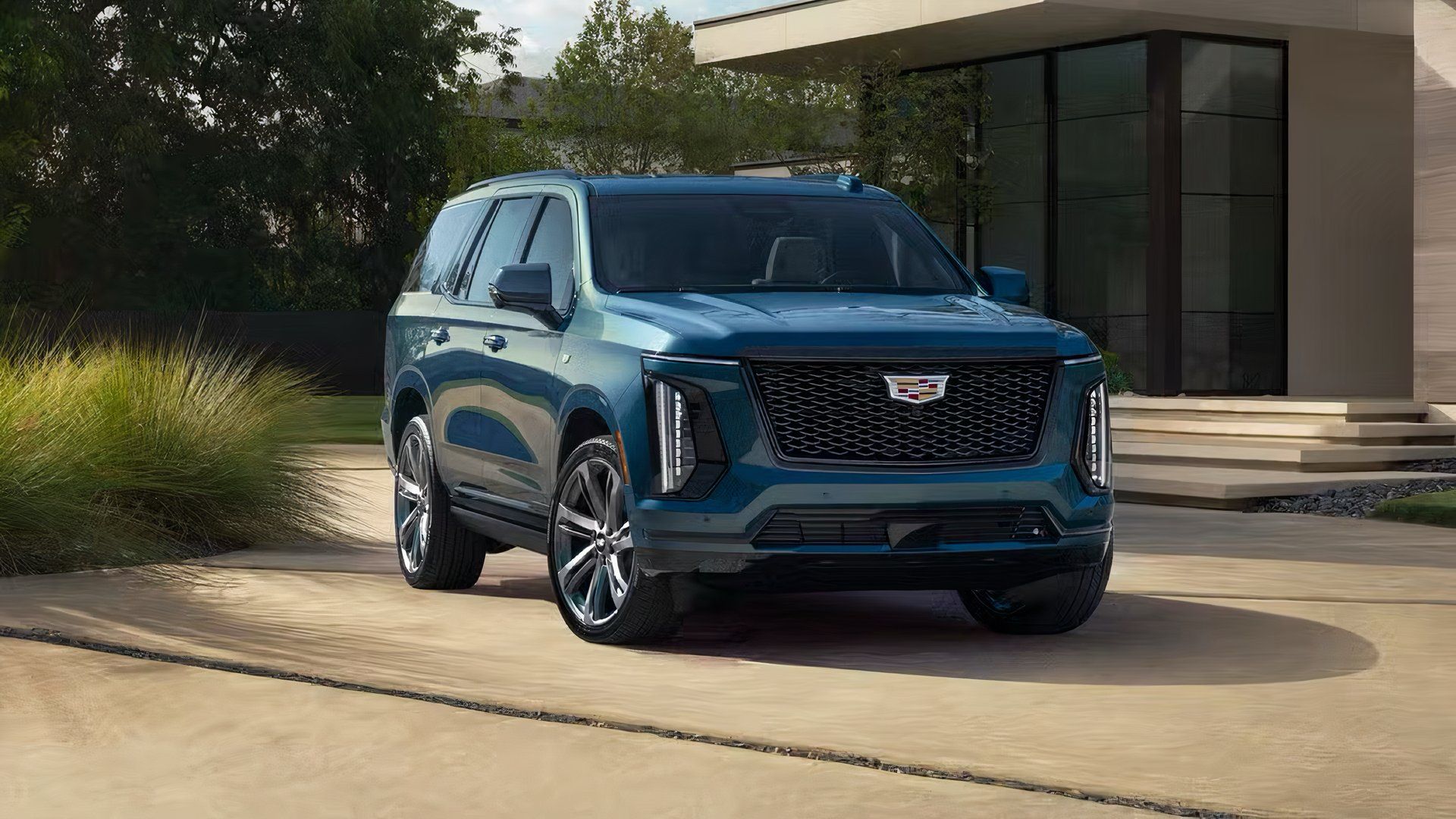 Foto frontal 3/4 do Cadillac Escalade 2025 em azul estacionado na garagem