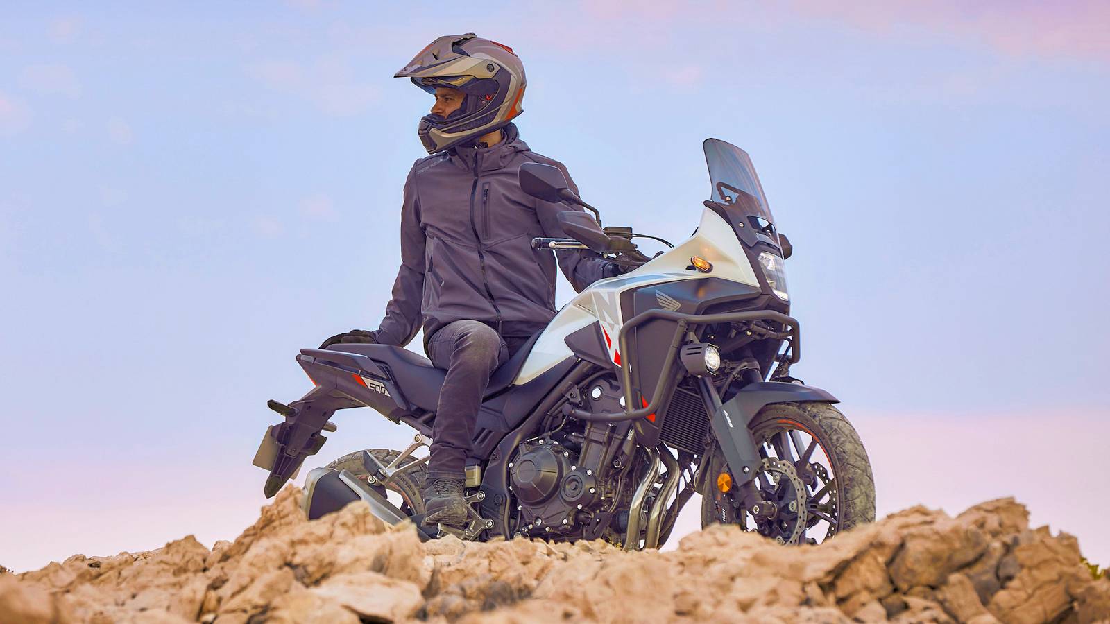 Una moto giapponese in movimento su terreni misti, con rider e motociclista in posizione centrale