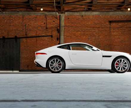 Um Jaguar F-Type 2017 visto de lado em um armazém