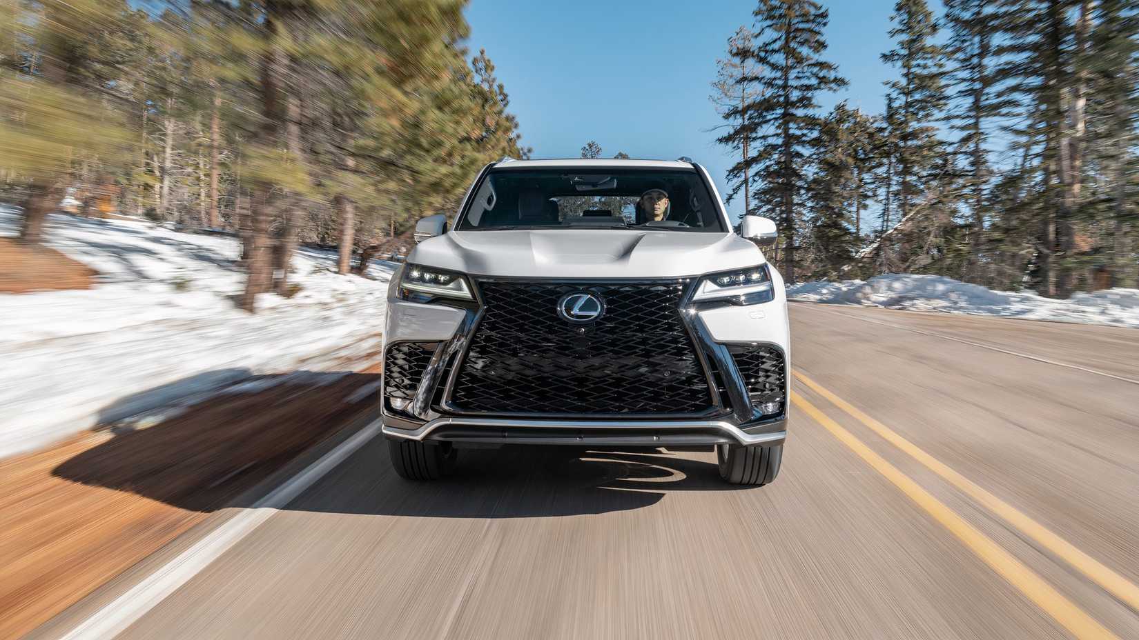 Foto frontal de um Lexus LX 600 F SPORT 2025 em branco dirigindo na estrada