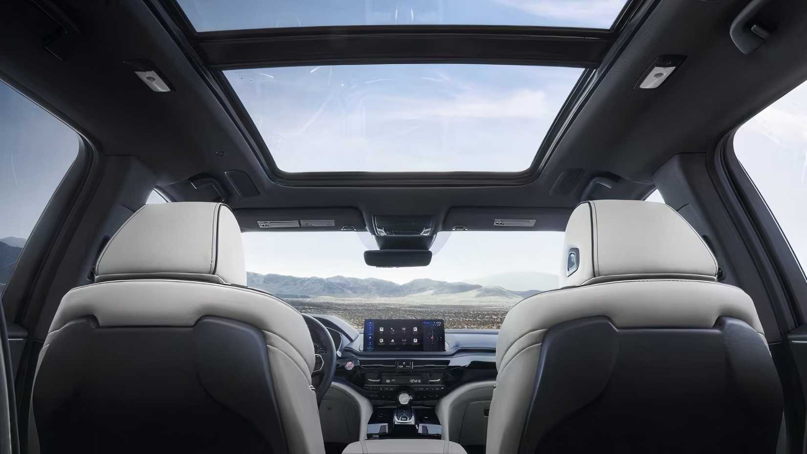 Interior do Acura MDX 2025 mostrando bancos dianteiros, janelas e teto