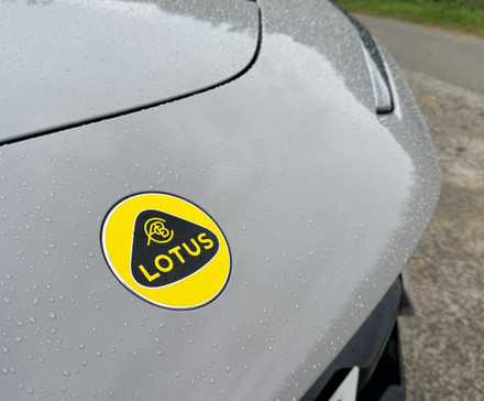 Close do emblema da Lotus na frente de um Lotus Eletre 600 Sport SE 2025 cinza.