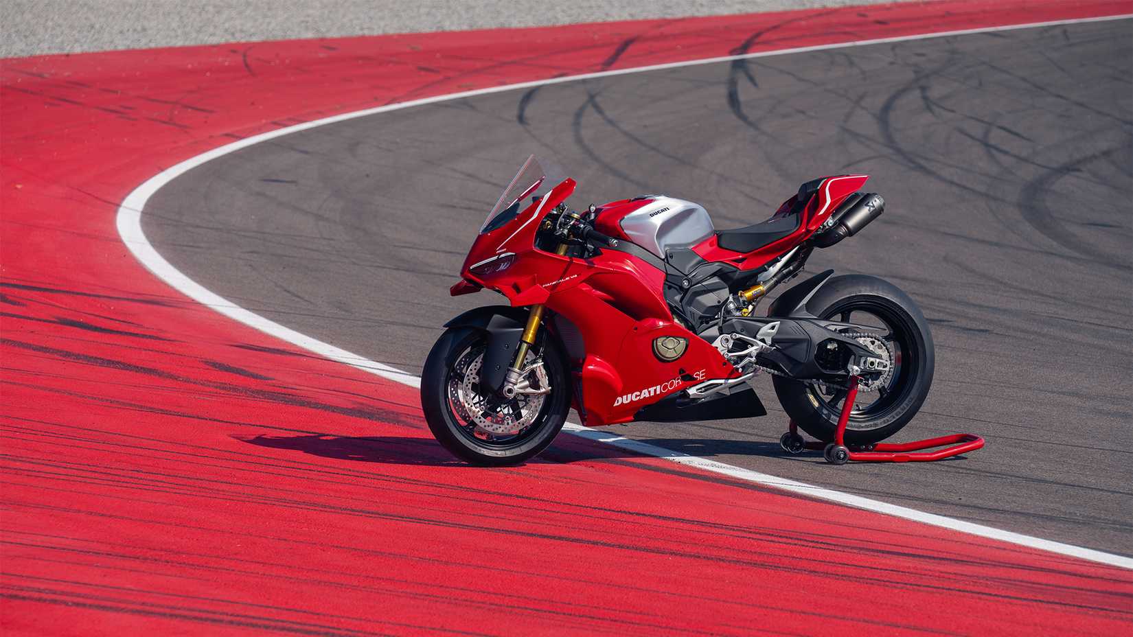 2026 Ducati Panigale V4 R vista lateral estacionada em um estande de paddock