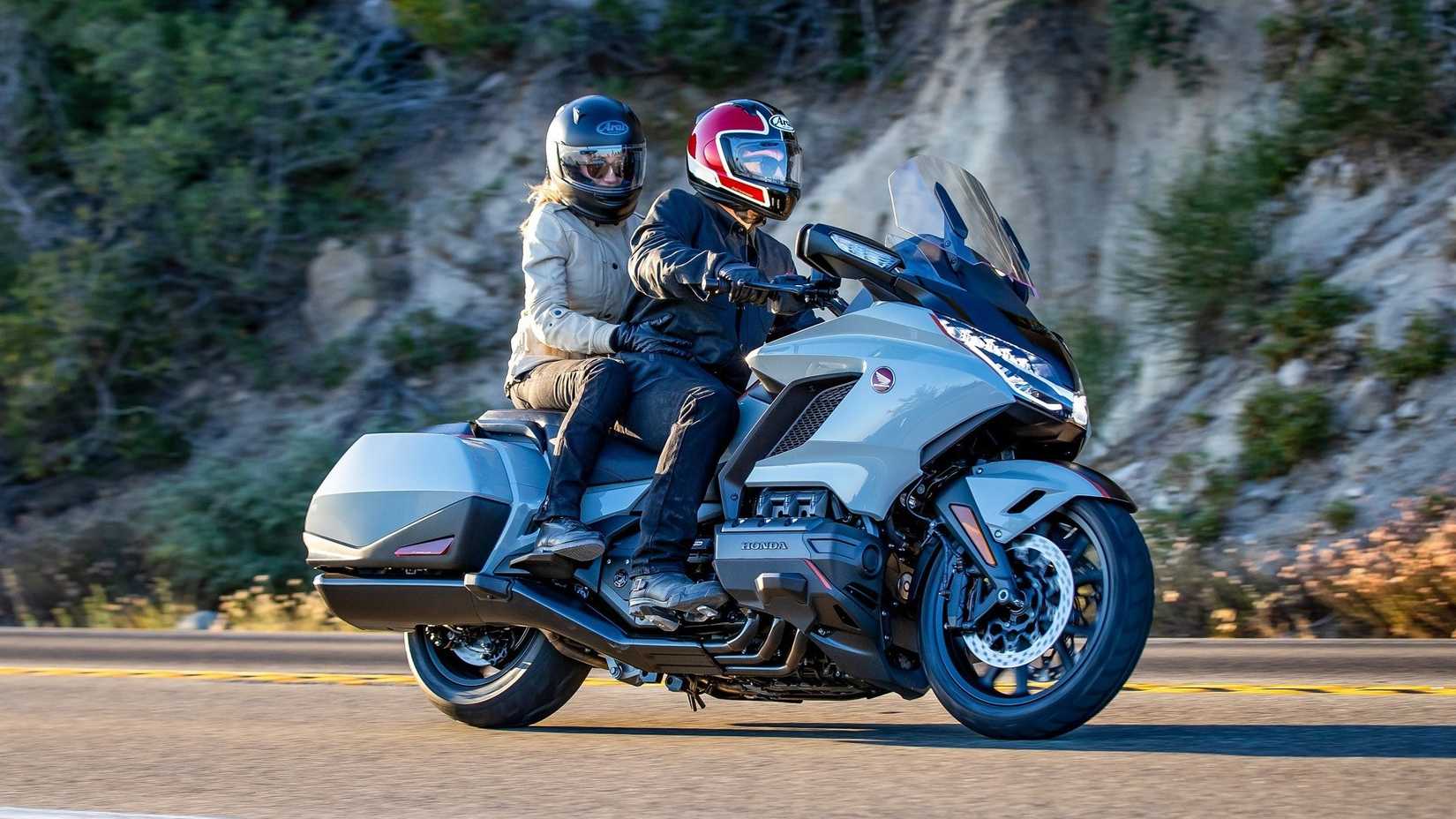Honda Gold Wing 2020 com piloto e passageiro acelerando vista de perfil lateral