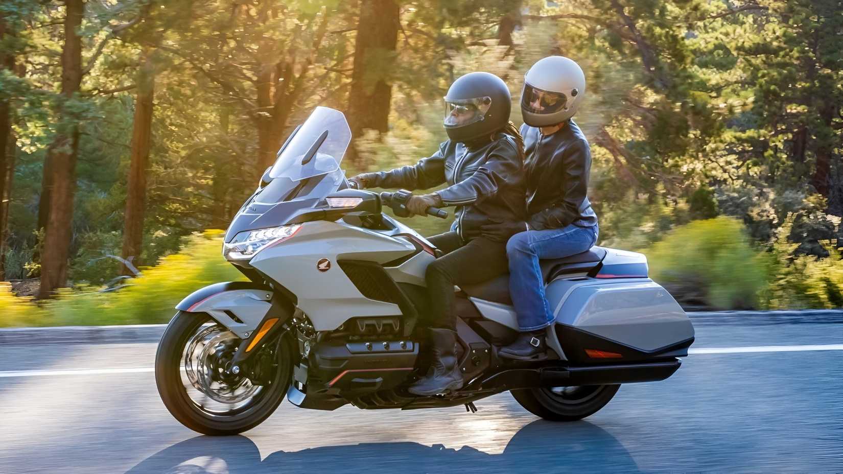 2020 Honda Goldwing touring with rider and pillion side profile view
