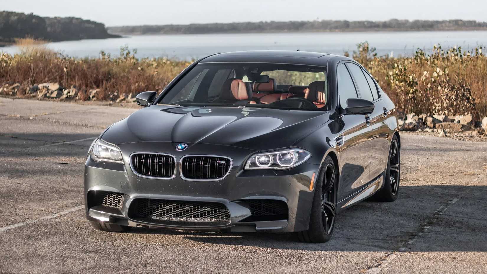 Foto frontal 3/4 do BMW M5 Competition 2015 em preto estacionado