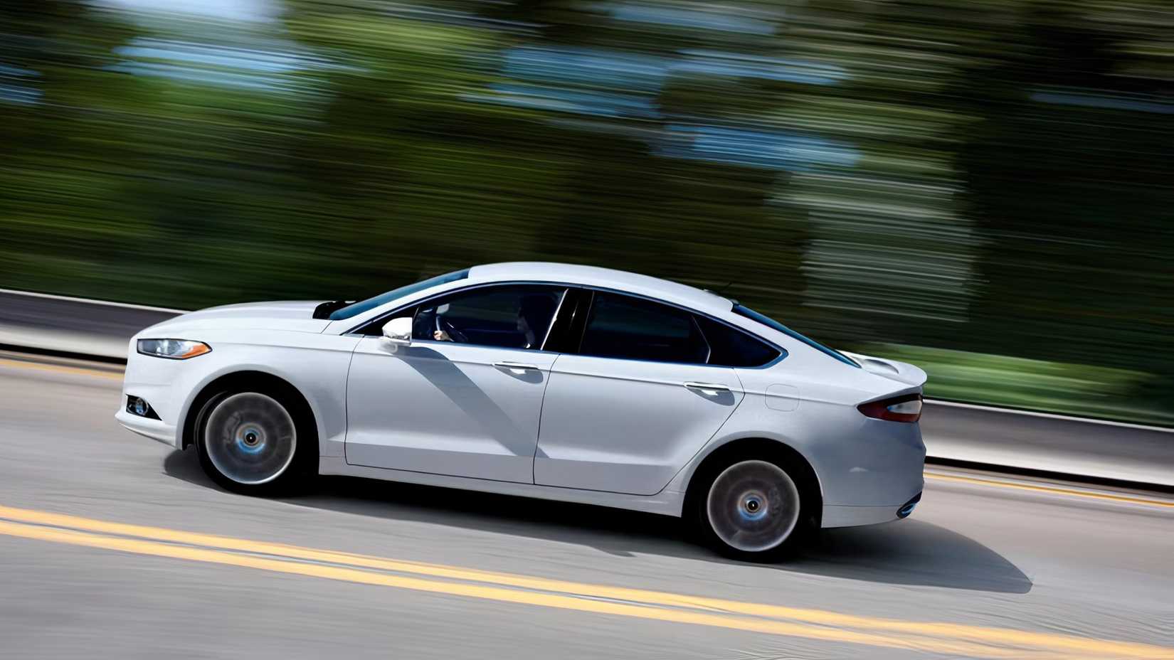 Foto lateral de um Ford Fusion 2015 sendo conduzido na estrada