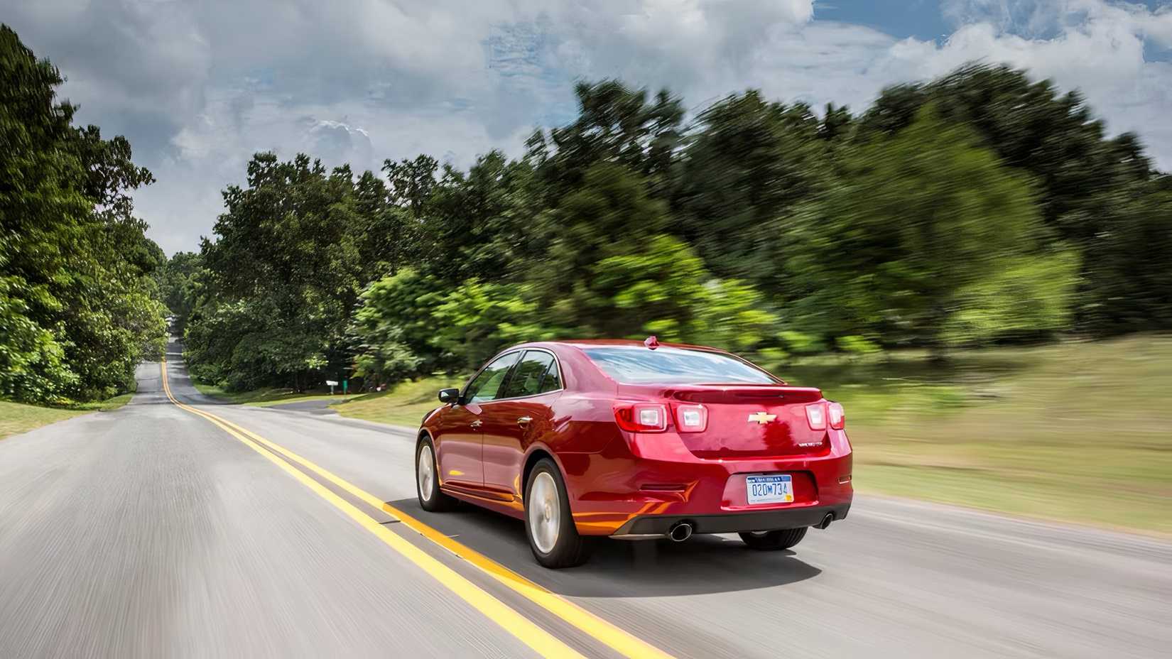 2015 Chevrolet Malibu in red being driven on road