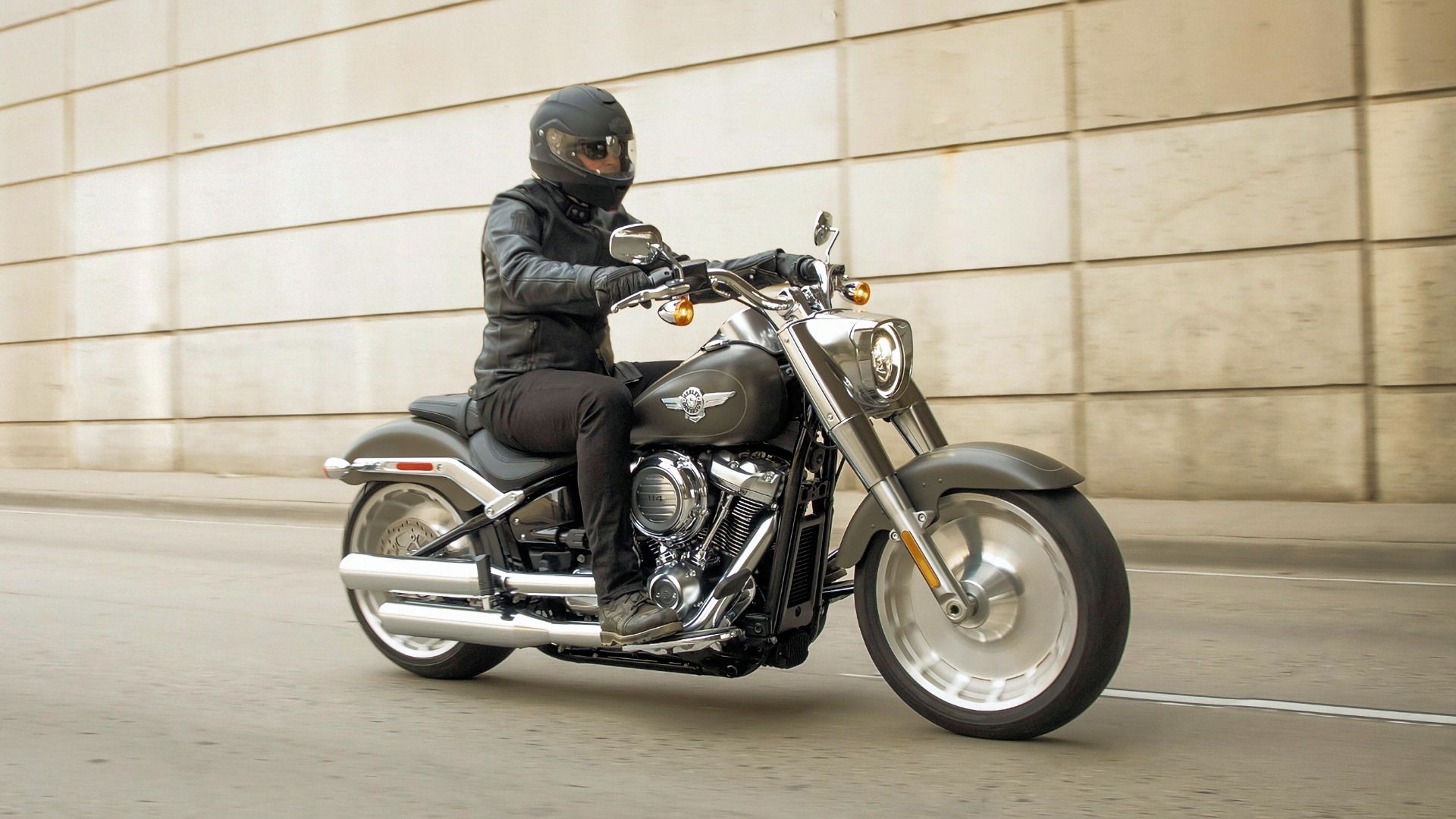 Rider on a 2019 Harley-Davidson Fat Boy cruising under an overpass