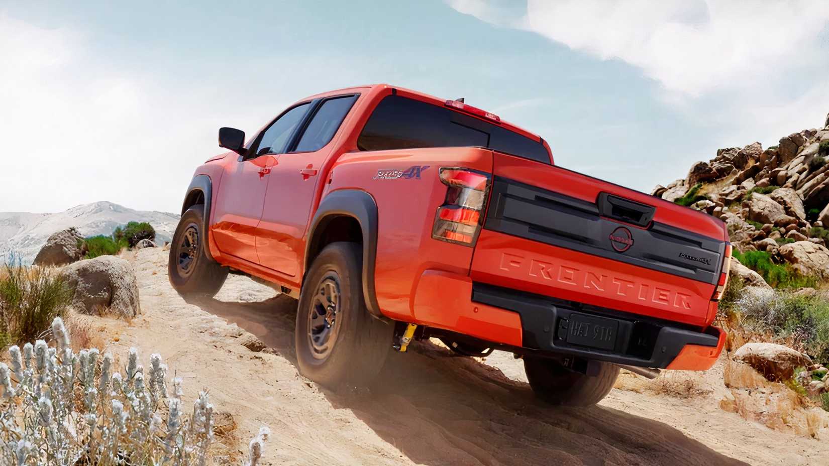 2026 Nissan Frontier em laranja dirigindo off-road