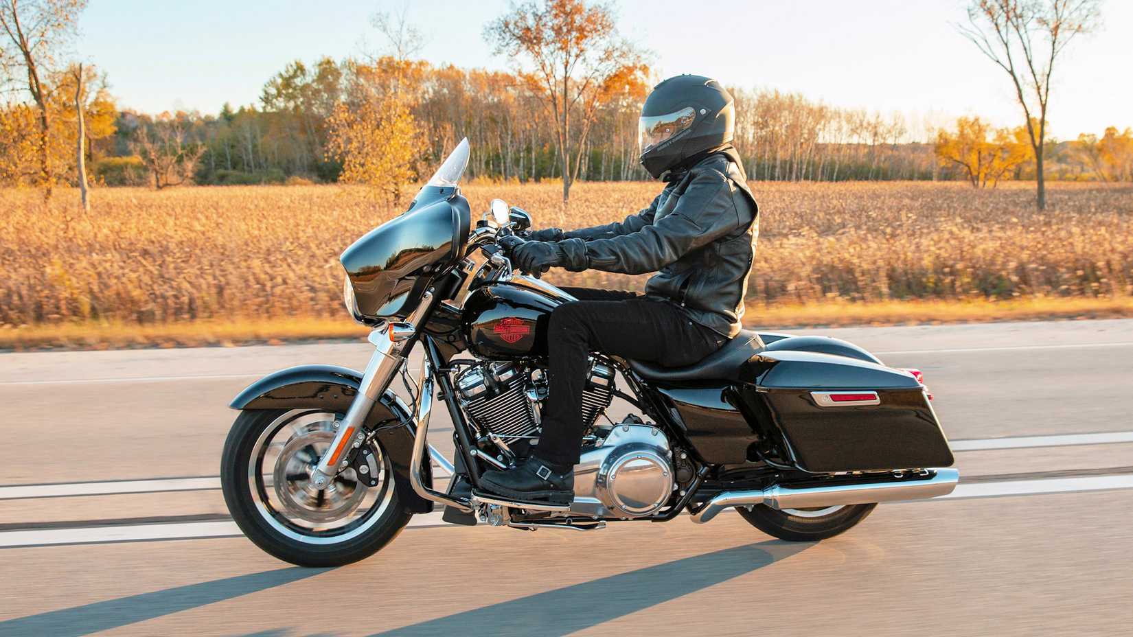 Rider on a black 2021 Harley-Davidson Electra Glide Standard cruising on a country road