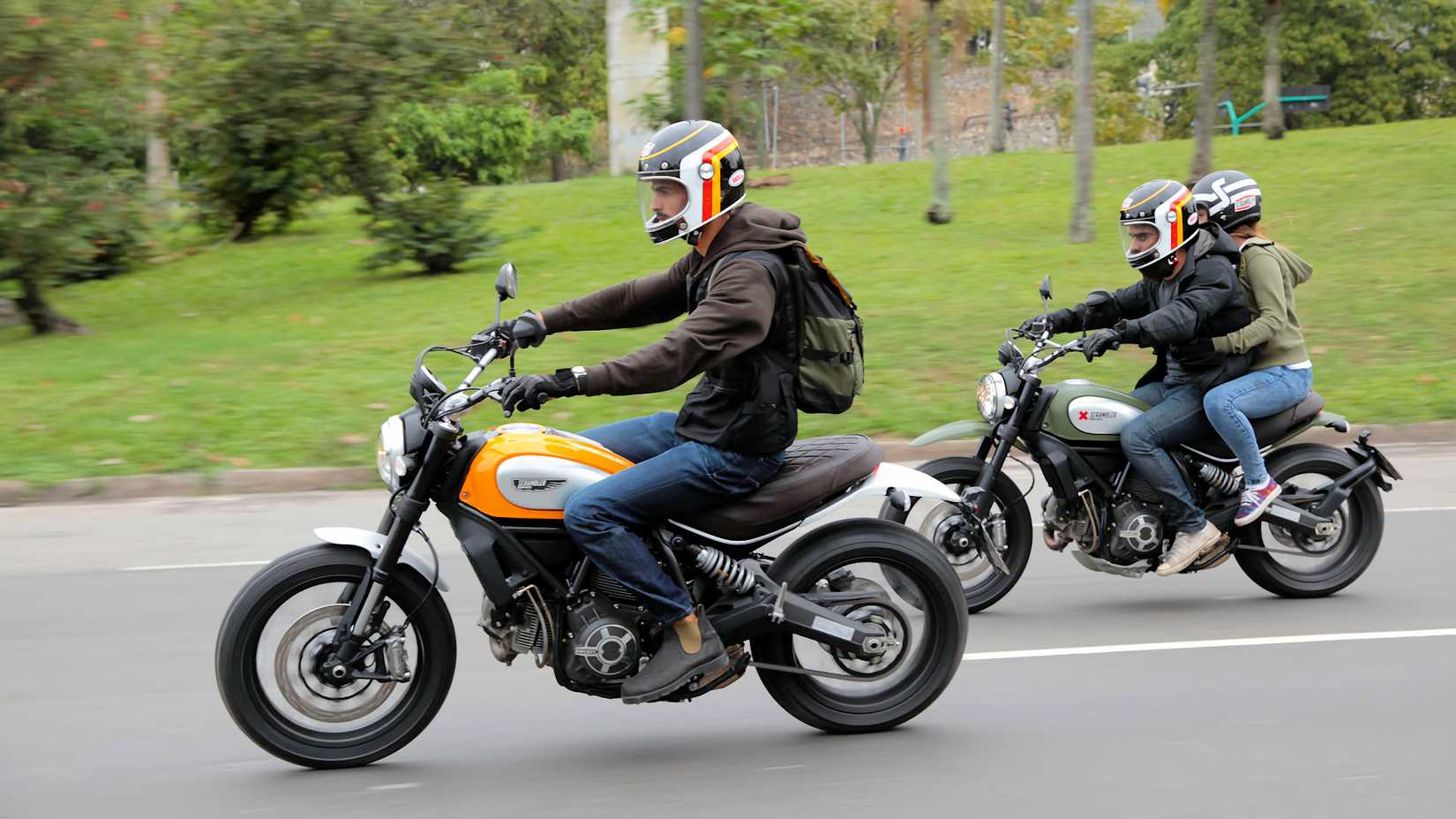 Pilotos em motocicletas Ducati Scrambler 2015 em uma estrada