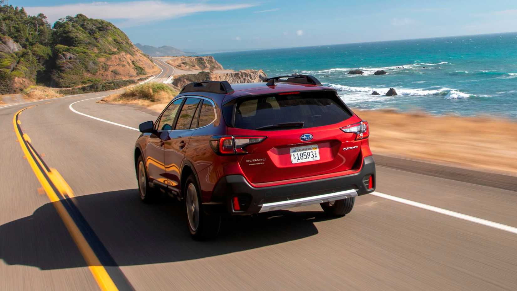 Uma foto dinâmica de rastreamento traseiro de um Subaru Outback 2022 vermelho