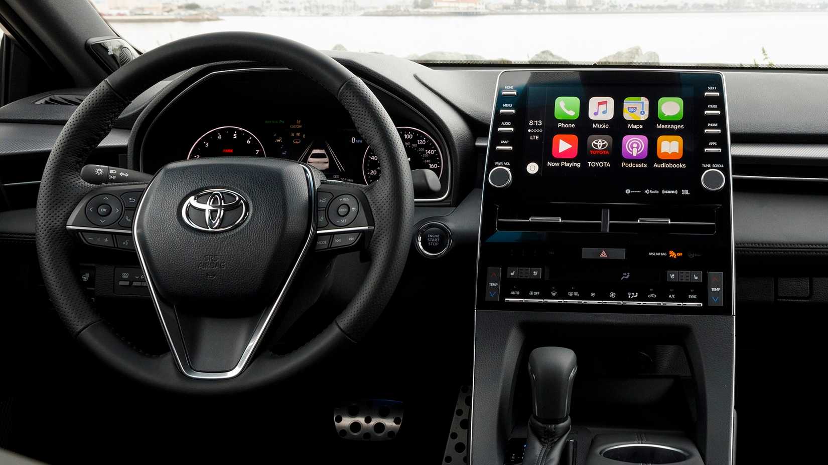 Interior do Toyota Avalon 2022 com volante e sistema de infoentretenimento