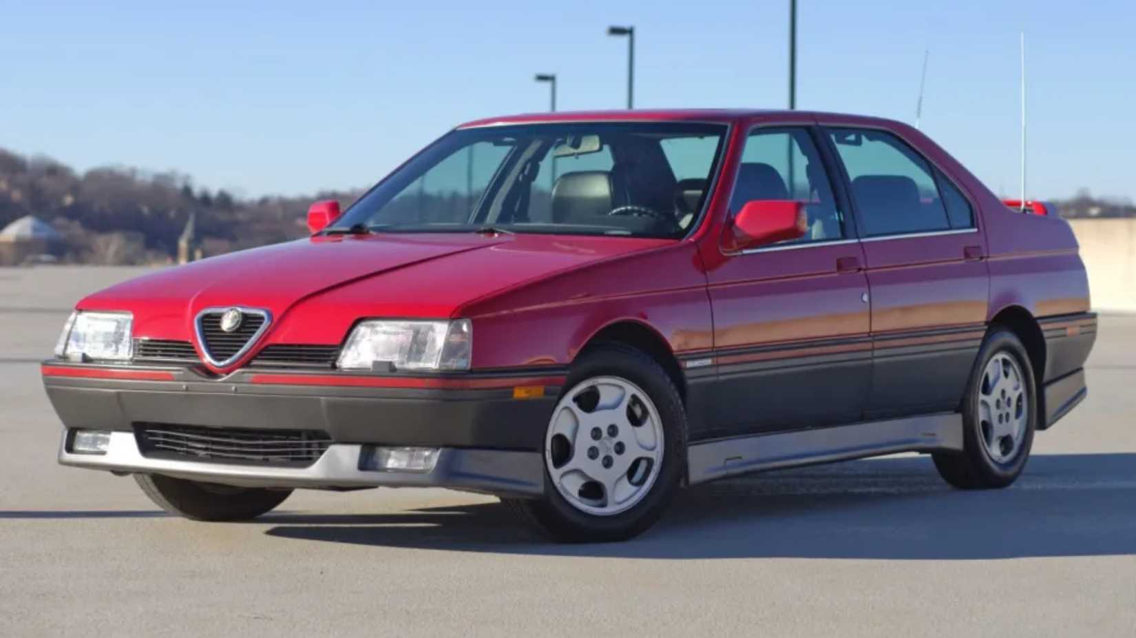 Front 3/4 shot of a red 1991 Alfa Romeo 164 in parking lot