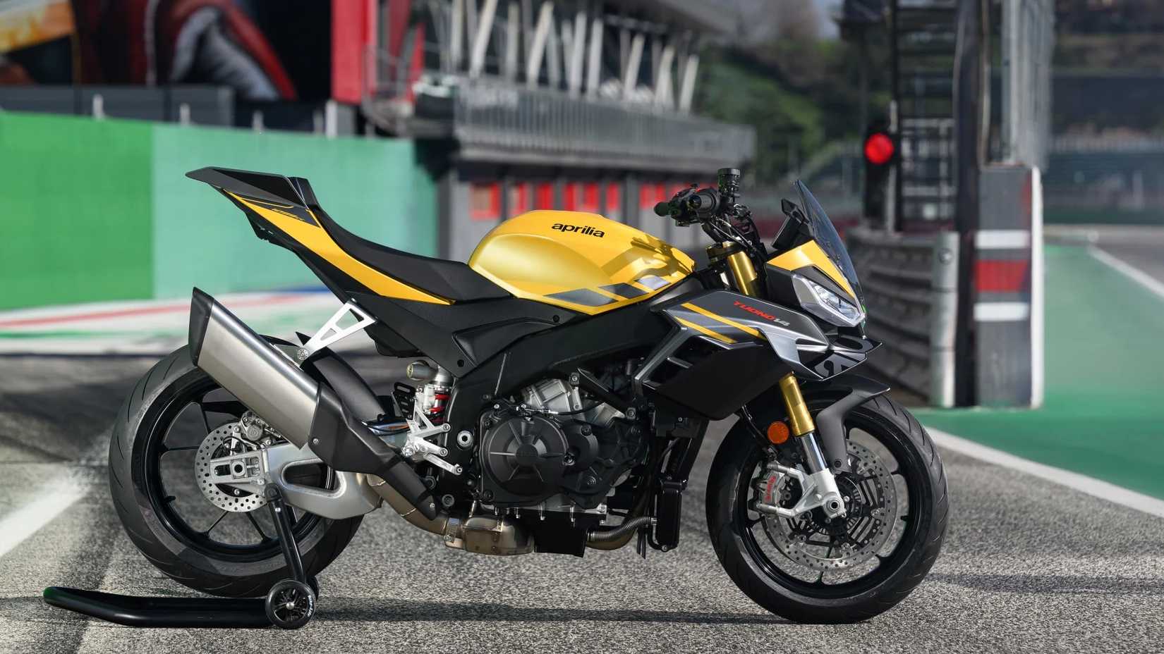 Imagem de perfil lateral de uma Aprilia Tuono V4 amarela 2025